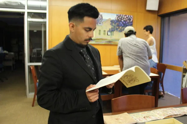 Student wearing a suit and reading a book