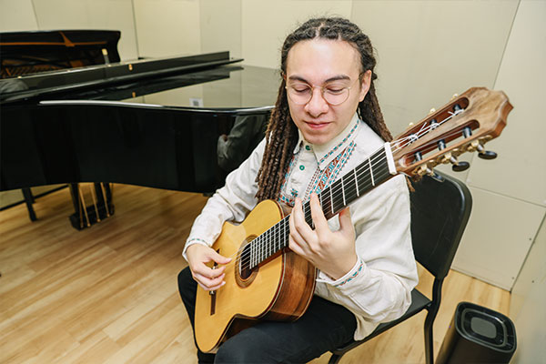 A student playing a guitar