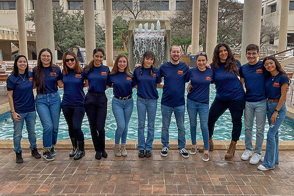 Students in the advisory council posing in front of the UTSA sombrilla fountain