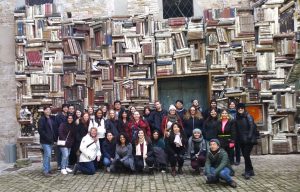 Group photo in front of wall of books